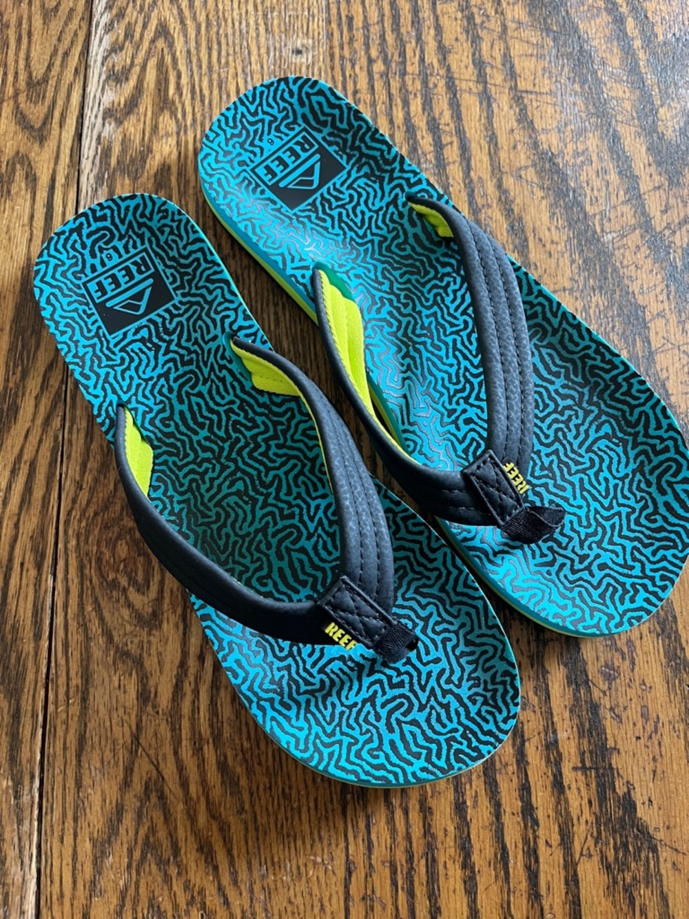 Reef Teal Patterned Flip Flops with Black Straps and Yellow Accents